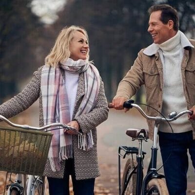 man and woman walking their bikes